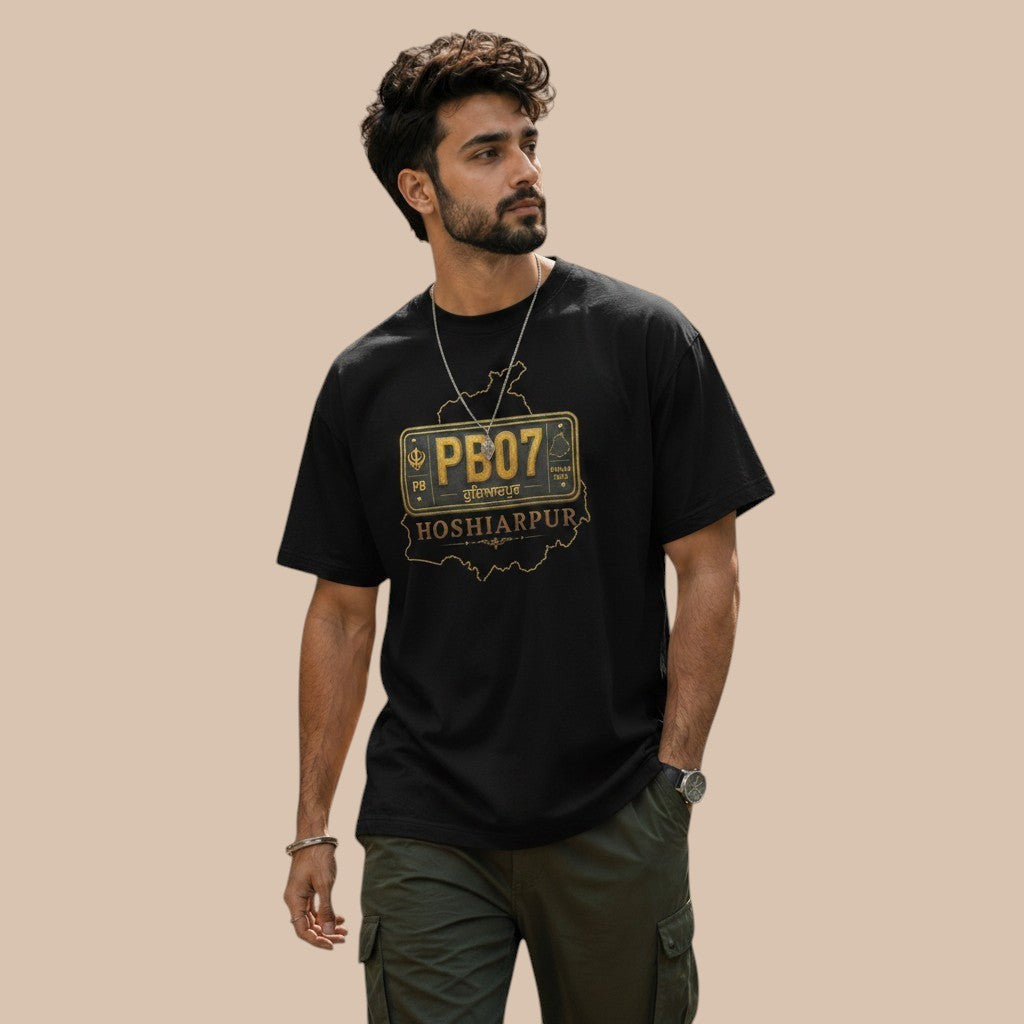 PUNJAB BOLDA black 100% cotton unisex classic tee with HOSHIARPUR graphic on front. Model is wearing cargo pants.